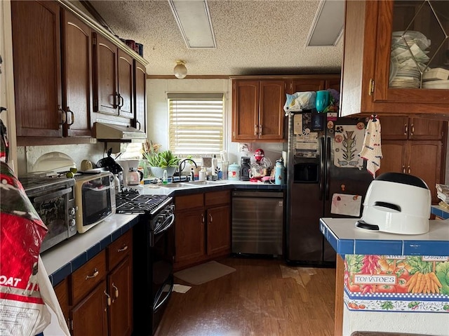 476 170th St, Fort Scott, KS 66701 - kitchen featuring black appliances, tile counters, a sink, under cabinet range hood, and wood finished floors
