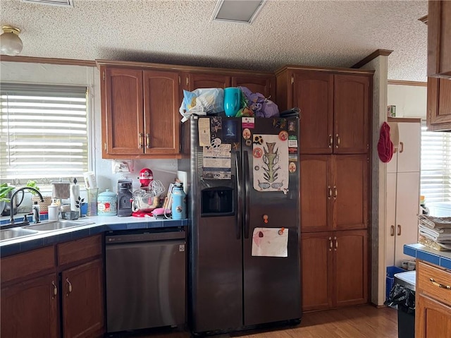 476 170th St, Fort Scott, KS 66701 - kitchen with fridge with ice dispenser, stainless steel dishwasher, tile countertops, ornamental molding, and a textured ceiling