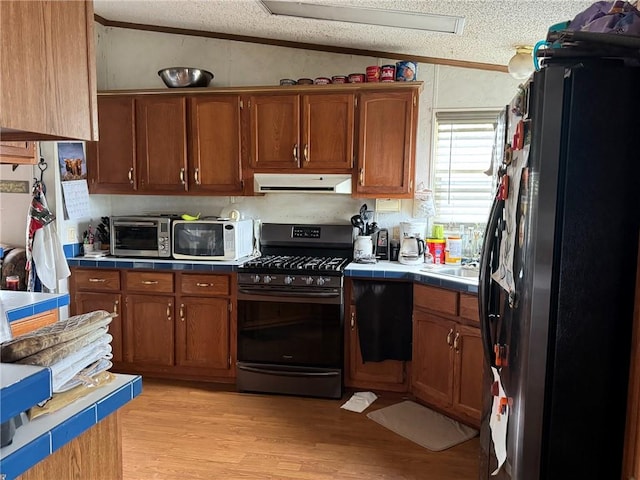 476 170th St, Fort Scott, KS 66701 - kitchen with range with gas stovetop, refrigerator with ice dispenser, white microwave, tile countertops, and a textured ceiling