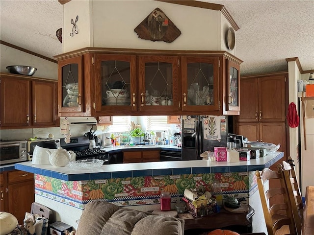 476 170th St, Fort Scott, KS 66701 - kitchen with a textured ceiling, stainless steel appliances, exhaust hood, a peninsula, and brown cabinetry