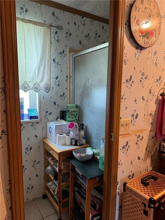 476 170th St, Fort Scott, KS 66701 - bathroom featuring wallpapered walls, tile patterned floors, a shower with shower door, and a textured ceiling