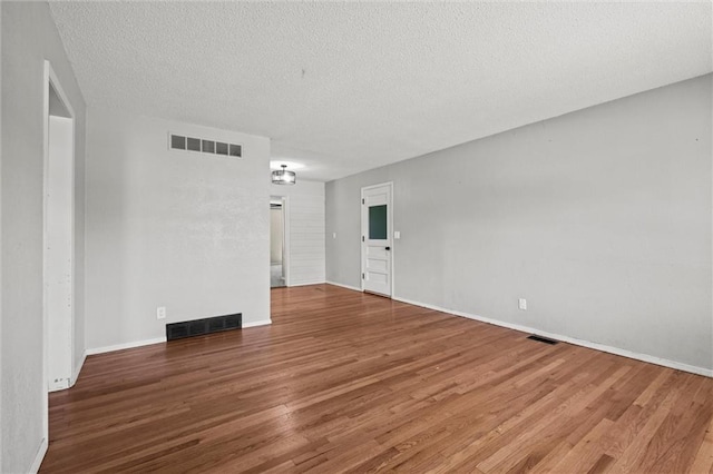 17207 E Swope Ln, Independence, MO 64056 - empty room with wood finished floors, a textured ceiling, and baseboards