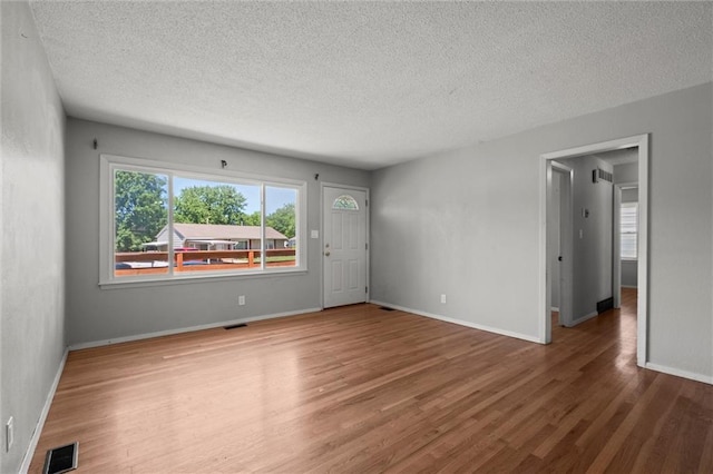 17207 E Swope Ln, Independence, MO 64056 - empty room with wood finished floors, a textured ceiling, and baseboards