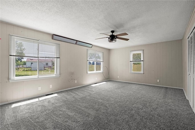 17207 E Swope Ln, Independence, MO 64056 - carpeted empty room featuring ceiling fan, wood walls, and a textured ceiling