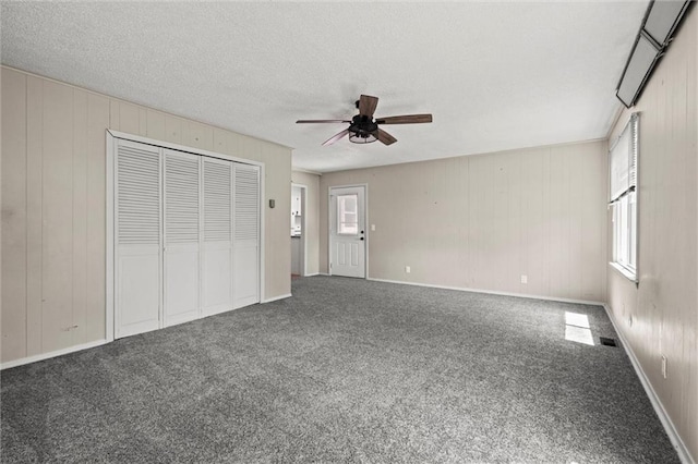 17207 E Swope Ln, Independence, MO 64056 - unfurnished living room with a ceiling fan, carpet, plenty of natural light, and a textured ceiling