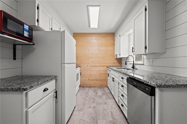 17207 E Swope Ln, Independence, MO 64056 - kitchen featuring stainless steel dishwasher, a sink, wood walls, white cabinetry, and dark stone countertops