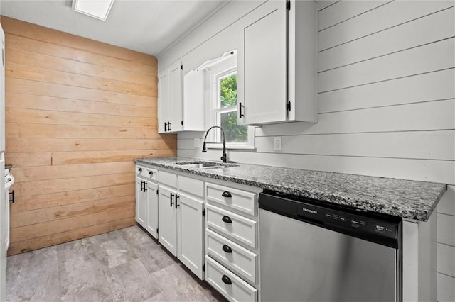 17207 E Swope Ln, Independence, MO 64056 - kitchen with dishwasher, wooden walls, a sink, white cabinets, and dark stone counters