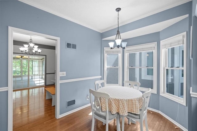 6221 W 126th Ter, Overland Park, KS 66209 - dining space with a chandelier, wood finished floors, and ornamental molding