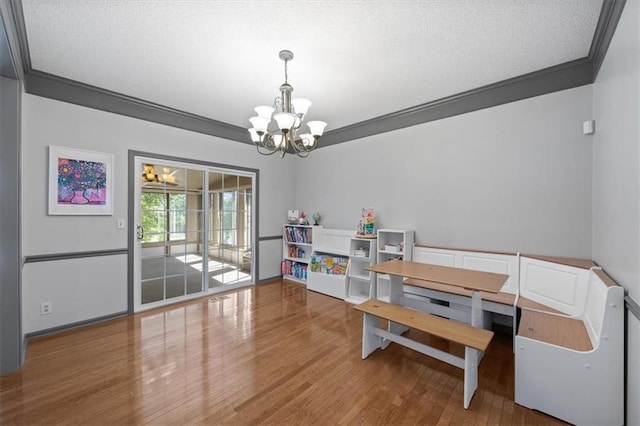 6221 W 126th Ter, Overland Park, KS 66209 - dining area with a chandelier, wood finished floors, crown molding, and a textured ceiling