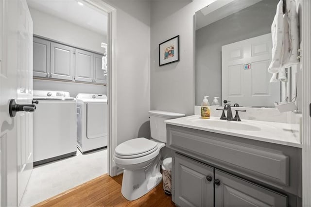 6221 W 126th Ter, Overland Park, KS 66209 - bathroom featuring washer and dryer, wood finished floors, and vanity