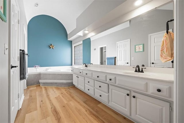 6221 W 126th Ter, Overland Park, KS 66209 - bathroom featuring double vanity, a bath, and wood finished floors