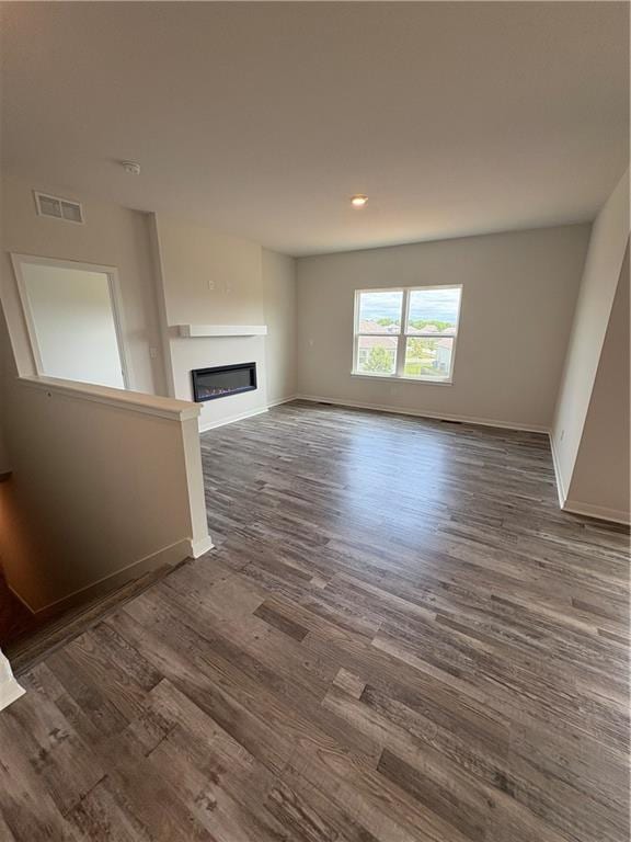 19605 W 200th St, Spring Hill, KS 66083 - unfurnished living room with a glass covered fireplace, baseboards, dark wood finished floors, and recessed lighting