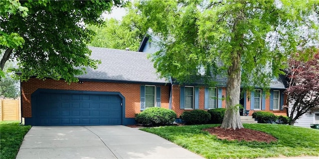 13106 E 57th St, Kansas City, MO 64133 - view of front of property featuring driveway, roof with shingles, brick siding, and a garage