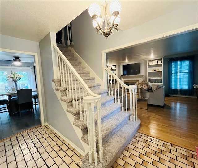 13106 E 57th St, Kansas City, MO 64133 - stairs featuring a chandelier, ceiling fan, baseboards, and wood finished floors