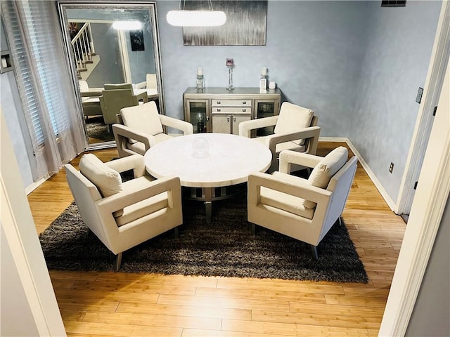 13106 E 57th St, Kansas City, MO 64133 - living area with wood finished floors, wine cooler, baseboards, and stairs