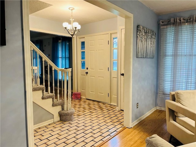 13106 E 57th St, Kansas City, MO 64133 - foyer with baseboards, a chandelier, stairs, and wood finished floors