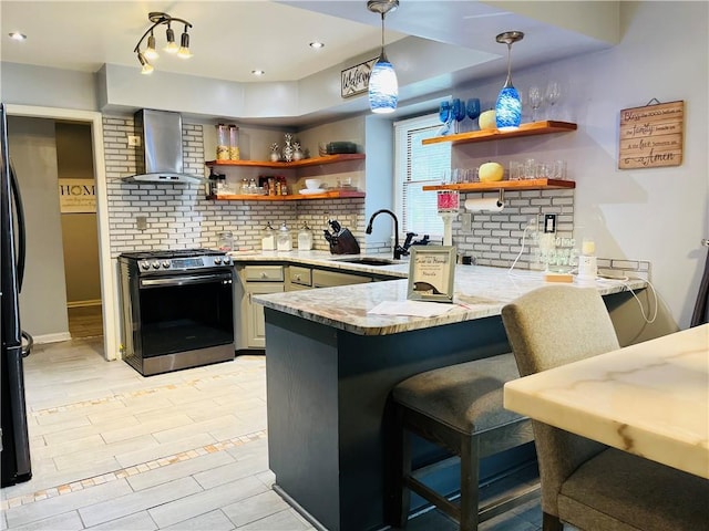 13106 E 57th St, Kansas City, MO 64133 - kitchen with wall chimney range hood, stainless steel gas range, open shelves, a sink, and a peninsula