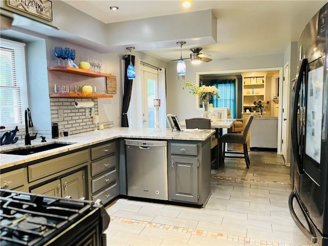 13106 E 57th St, Kansas City, MO 64133 - kitchen with black refrigerator, dishwasher, gray cabinets, a sink, and a peninsula