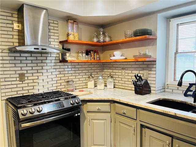 13106 E 57th St, Kansas City, MO 64133 - kitchen with stainless steel gas stove, wall chimney range hood, a sink, and tasteful backsplash