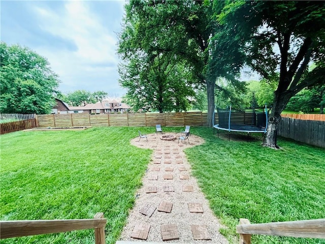13106 E 57th St, Kansas City, MO 64133 - view of yard featuring a trampoline and an outdoor fire pit