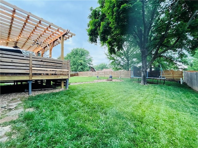 13106 E 57th St, Kansas City, MO 64133 - view of yard with a trampoline, a pergola, and a wooden deck