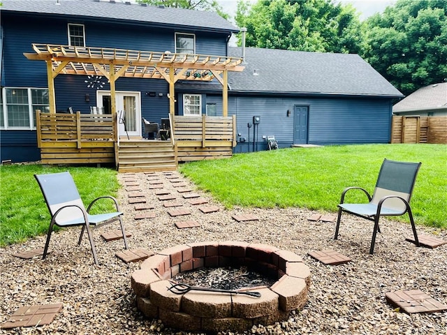13106 E 57th St, Kansas City, MO 64133 - back of property featuring an outdoor fire pit, a pergola, a wooden deck, a lawn, and a shingled roof