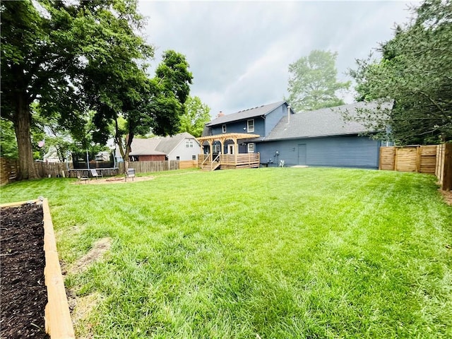 13106 E 57th St, Kansas City, MO 64133 - view of yard featuring a trampoline and a wooden deck