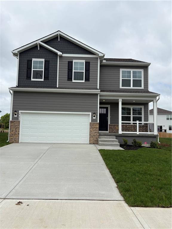 19611 W 201st St, Spring Hill, KS 66083 - craftsman house with concrete driveway, an attached garage, a front yard, covered porch, and stone siding