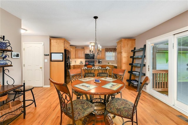 800 Ash Ct, Lansing, KS 66043 - dining space with light wood-type flooring, healthy amount of natural light, and a chandelier