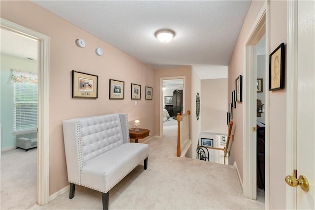 800 Ash Ct, Lansing, KS 66043 - hallway featuring an upstairs landing, light carpet, baseboards, and a textured ceiling
