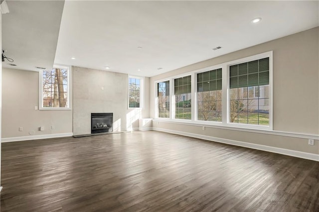 15142 Windsor Cir, Leawood, KS 66224 - unfurnished living room with dark wood-style flooring, a tiled fireplace, and recessed lighting