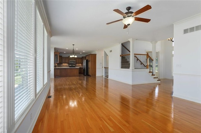 3104 SE 2nd St, Lees Summit, MO 64063 - unfurnished living room with a chandelier, light wood finished floors, stairs, a ceiling fan, and recessed lighting