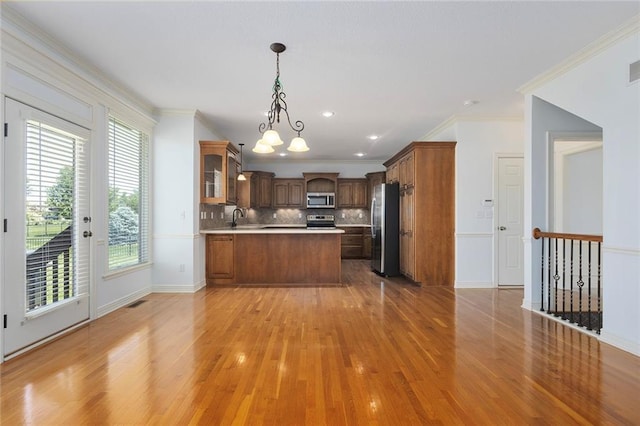 3104 SE 2nd St, Lees Summit, MO 64063 - kitchen featuring appliances with stainless steel finishes, light wood-type flooring, a peninsula, a sink, and a chandelier