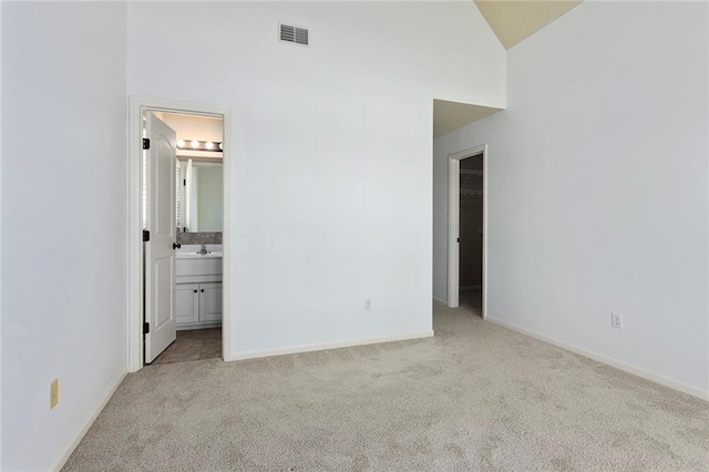 3104 SE 2nd St, Lees Summit, MO 64063 - unfurnished bedroom featuring carpet floors, a walk in closet, baseboards, ensuite bath, and high vaulted ceiling