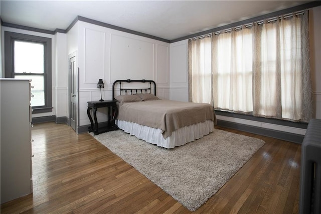 1017 Angelique St, Saint Joseph, MO 64501 - bedroom with a decorative wall, ornamental molding, and dark wood-style flooring