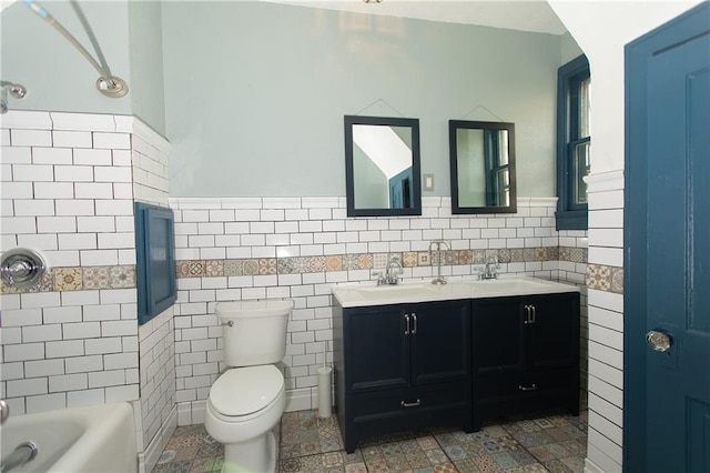 1017 Angelique St, Saint Joseph, MO 64501 - full bath with double vanity, toilet, wainscoting, and tile walls