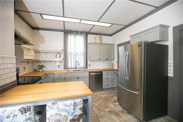 1017 Angelique St, Saint Joseph, MO 64501 - kitchen featuring butcher block countertops, stainless steel appliances, gray cabinets, wall chimney exhaust hood, and crown molding