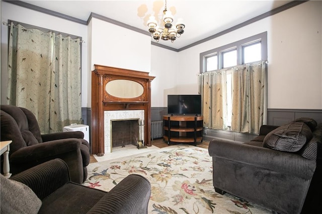 1017 Angelique St, Saint Joseph, MO 64501 - living area with crown molding, a chandelier, wainscoting, a fireplace with flush hearth, and radiator