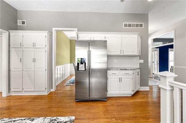 9816 W 132nd Ter, Overland Park, KS 66213 - kitchen with stainless steel fridge with ice dispenser, white cabinets, light wood-type flooring, backsplash, and light stone countertops
