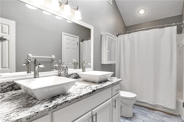 9816 W 132nd Ter, Overland Park, KS 66213 - full bathroom featuring double vanity, toilet, shower / bathtub combination with curtain, wood finished floors, and vaulted ceiling