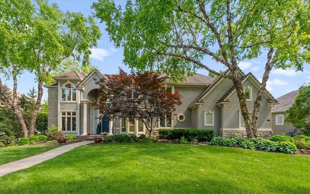 4829 W 144th Ter, Leawood, KS 66224 - traditional-style house featuring stucco siding, a front yard, and stone siding