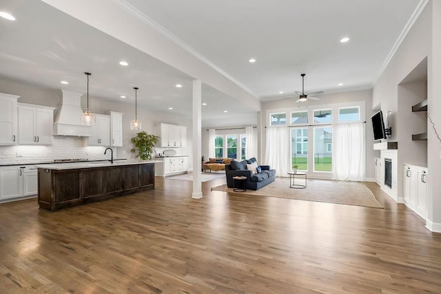 2055 NW Obrien Rd, Lees Summit, MO 64081 - living area with a ceiling fan, a glass covered fireplace, crown molding, recessed lighting, and dark wood-type flooring
