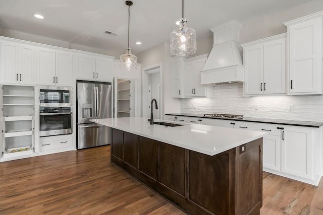 2055 NW Obrien Rd, Lees Summit, MO 64081 - kitchen featuring stainless steel appliances, dark wood-type flooring, custom range hood, backsplash, and white cabinets