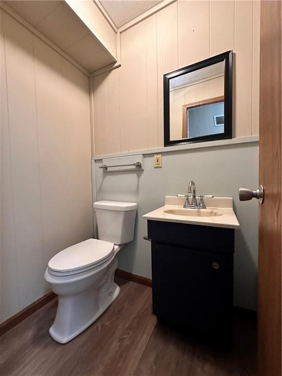 519 N Warren St, Warrensburg, MO 64093 - bathroom featuring wood finished floors, toilet, vanity, and baseboards