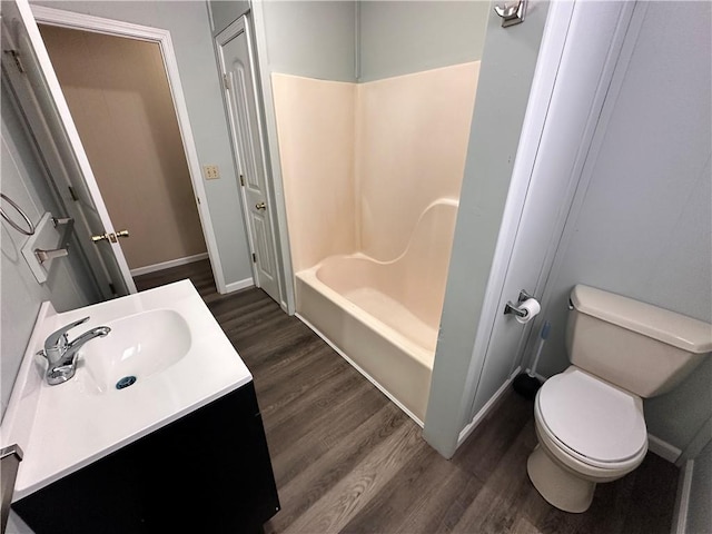 519 N Warren St, Warrensburg, MO 64093 - full bath with wood finished floors, toilet, baseboards, shower / washtub combination, and vanity