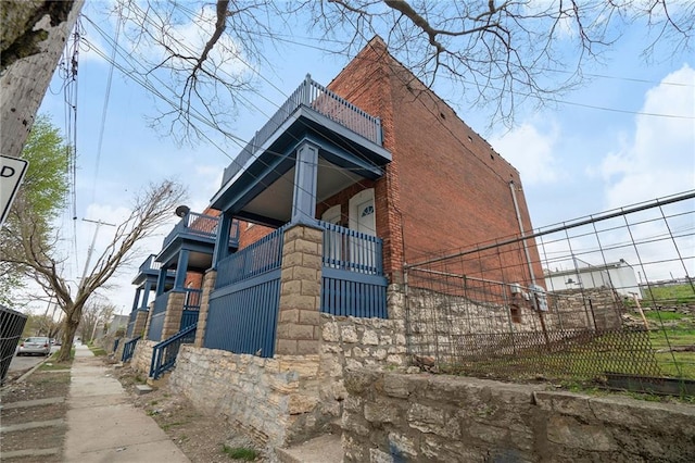412 Montgall Ave, Kansas City, MO 64124 - view of home's exterior with a balcony, brick siding, and stone siding