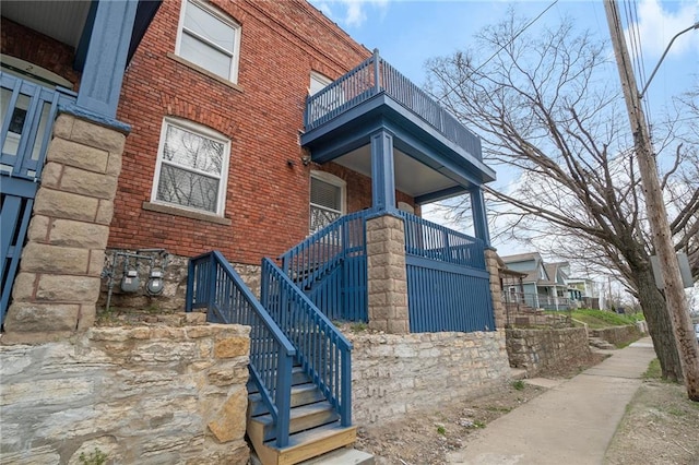 412 Montgall Ave, Kansas City, MO 64124 - doorway to property featuring a balcony and brick siding