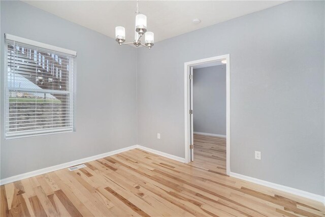 412 Montgall Ave, Kansas City, MO 64124 - unfurnished room with a chandelier, wood finished floors, and baseboards