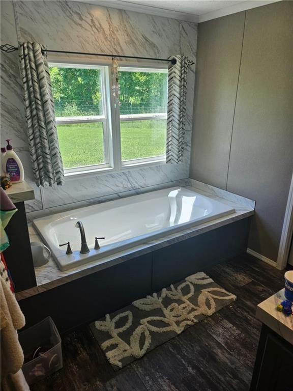 1292 255th St, Fort Scott, KS 66701 - bathroom with a garden tub, wood finished floors, vanity, and ornamental molding