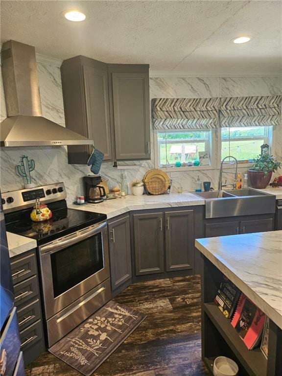 1292 255th St, Fort Scott, KS 66701 - kitchen with stainless steel electric range, wall chimney exhaust hood, a sink, light countertops, and a textured ceiling